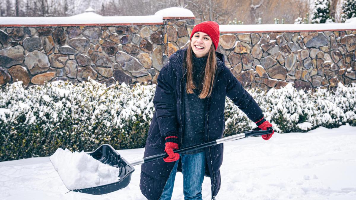 Девушка чистит снег
