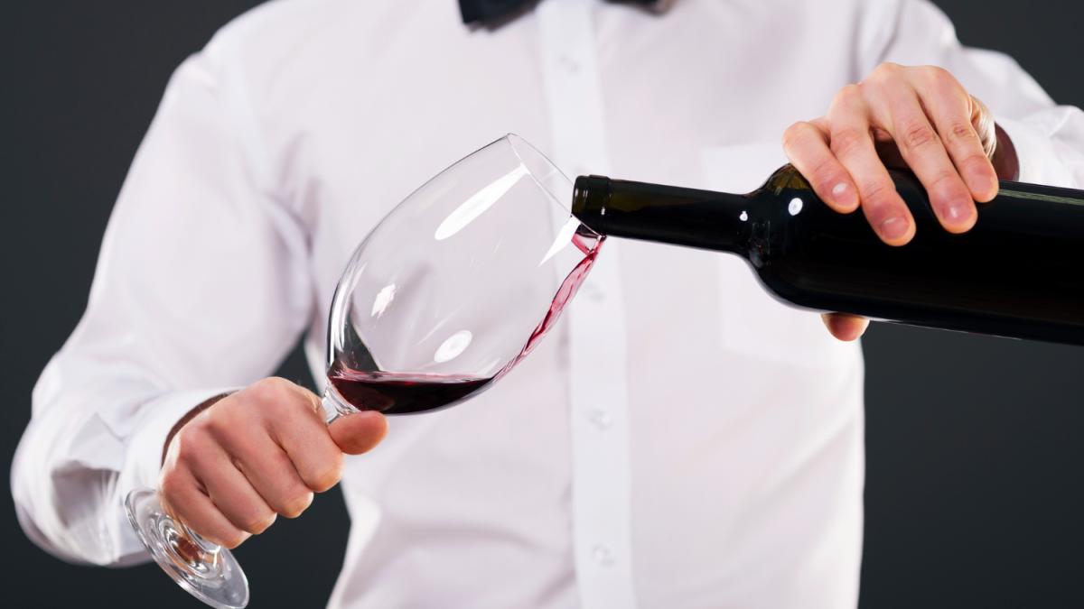Сомелье наливает вино в бокал