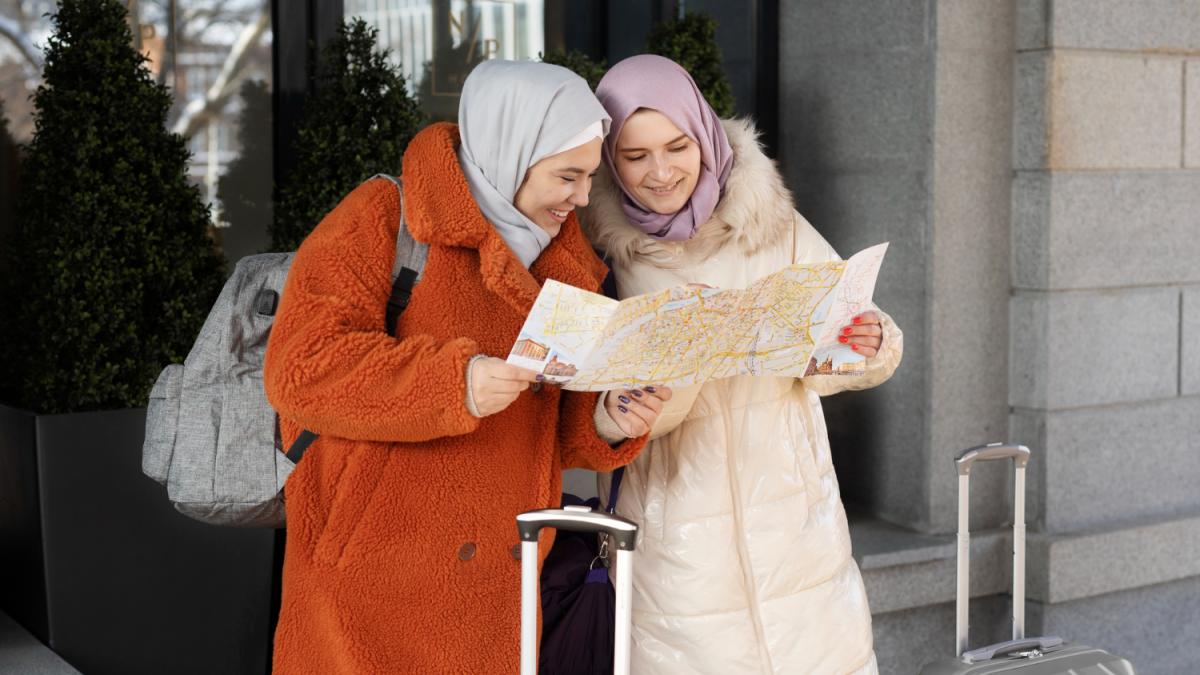 Мусульманки сверяются с картой перед отелем во время отпуска