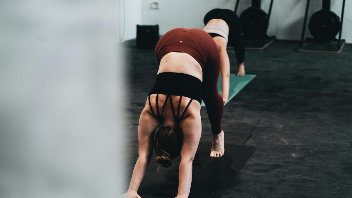 Девушкb делает растяжку в зале