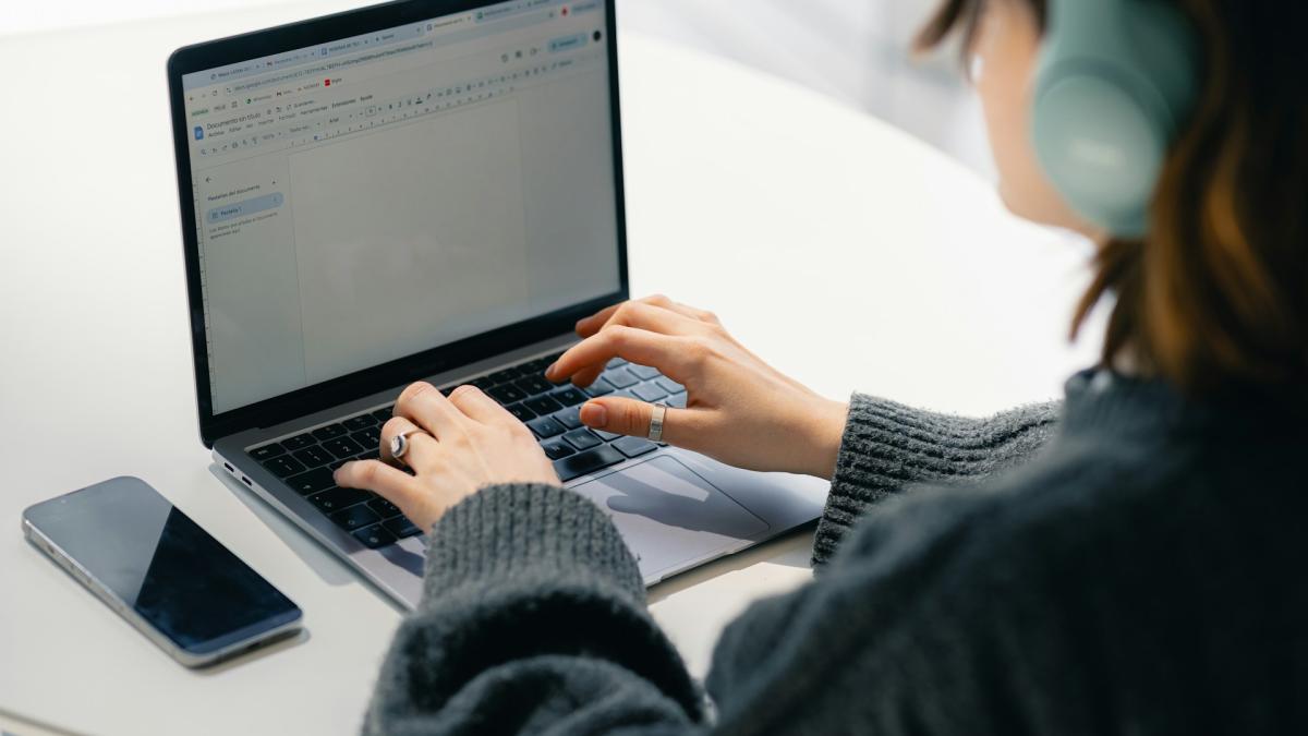 Девушка в наушниках работает за ноутбуком