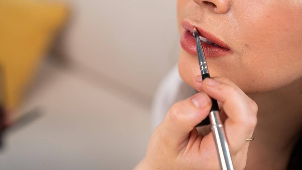 Девушка красит губы