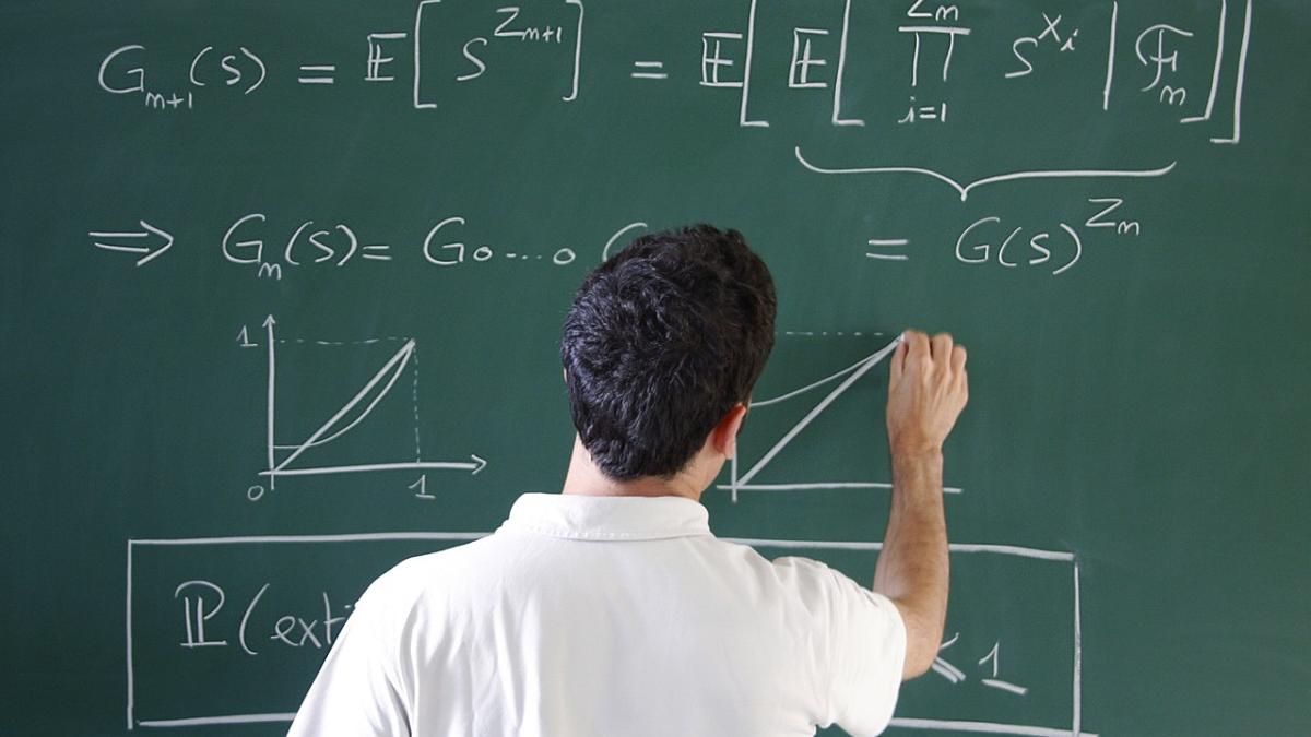 Мужчина решает задачу на доске