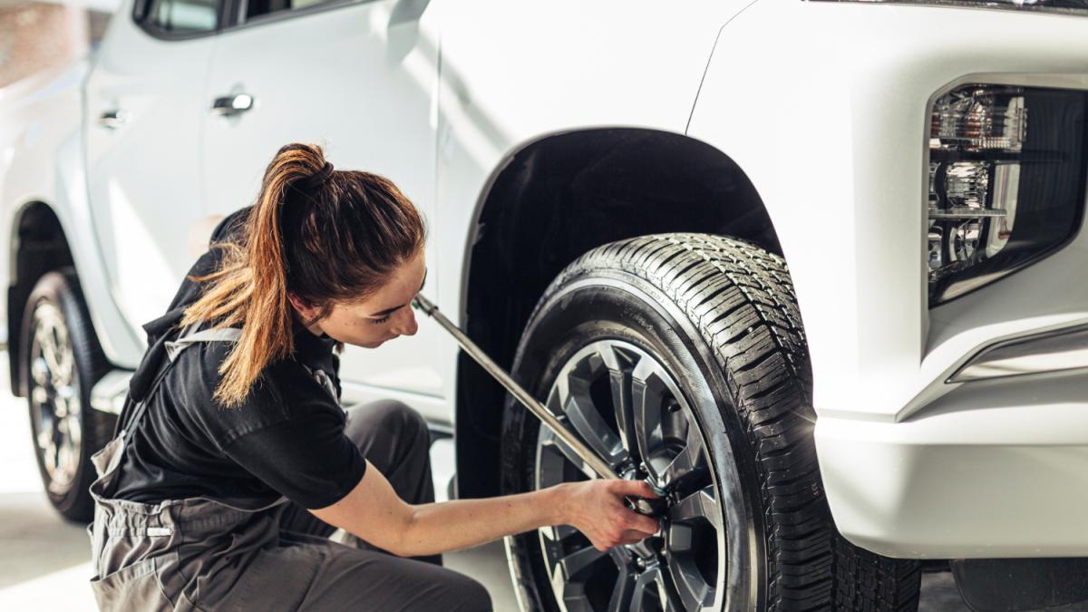 Смена колеса: человек с домкратом и баллонным ключом у колеса