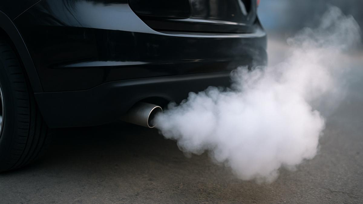Выхлопная труба автомобиля с белым дымом Выхлопная труба автомобиля с белым дымом