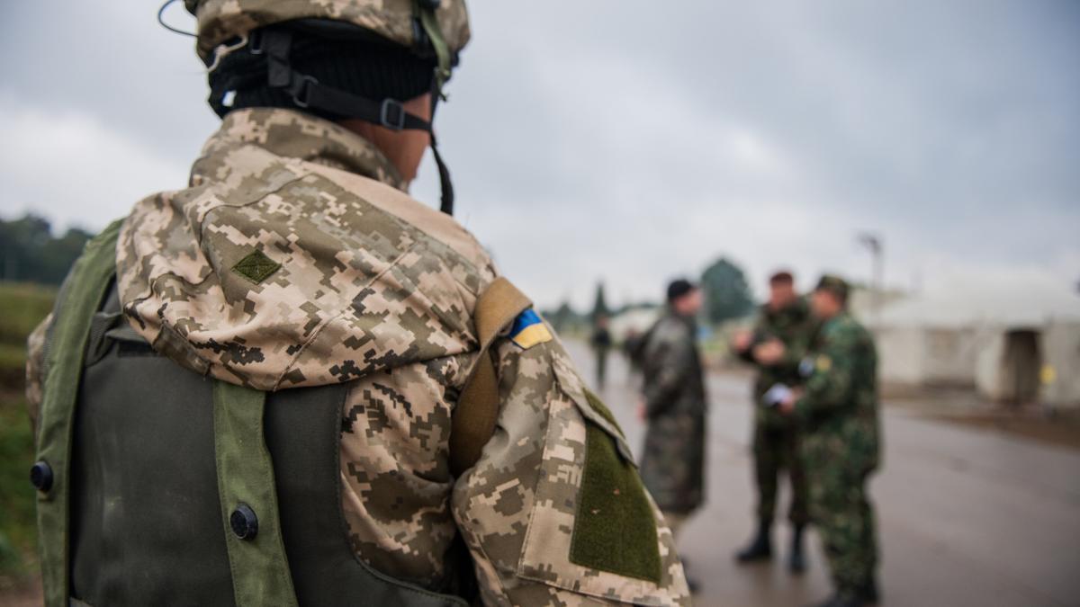 Украинский морской пехотинец наблюдает, как многонациональные участники допрашивают условного солдата