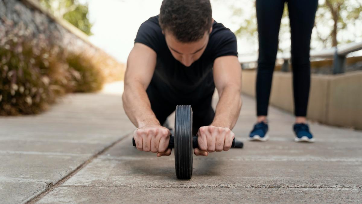 Мужчина тренируется с роликом