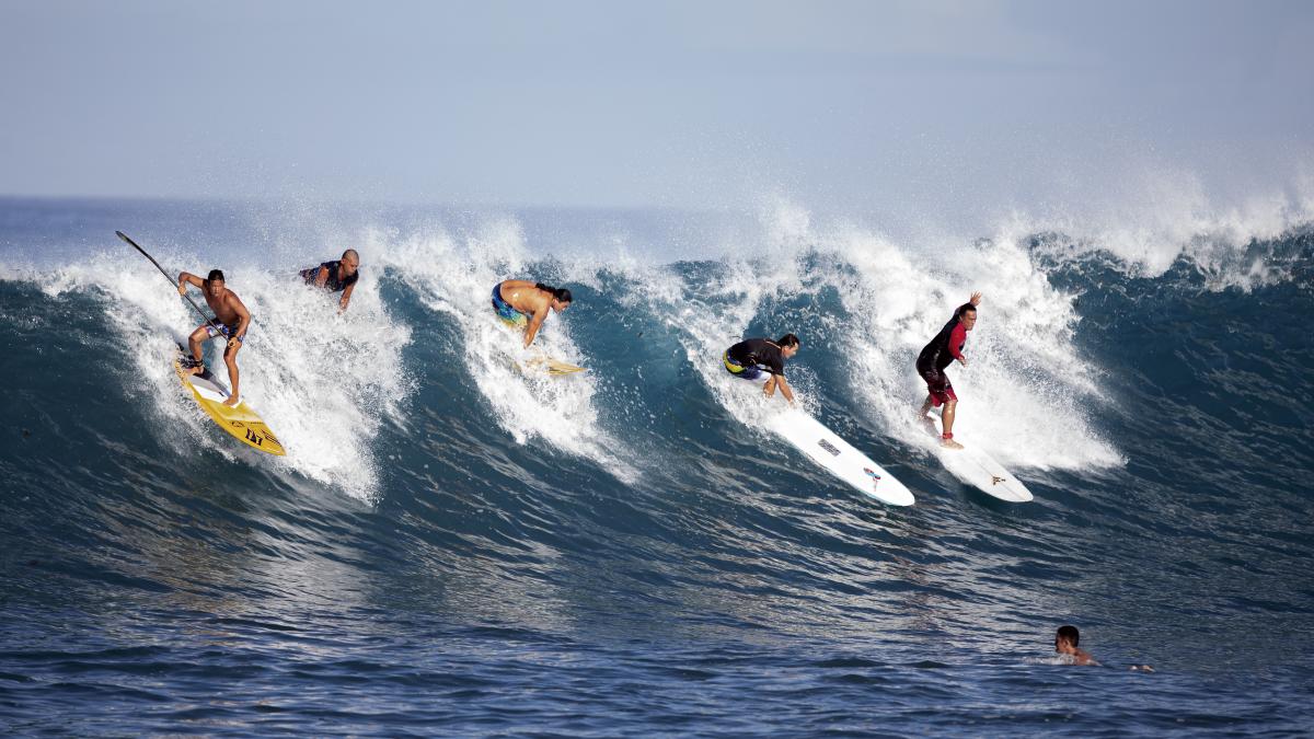 La horde - Surfers riding a wave in Paea, Tahiti