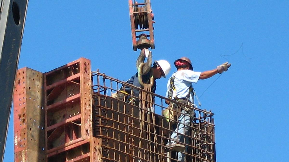 Строители автострады готовят бетонную форму для заливки бетона Строители автострады готовят бетонную форму для заливки бетона