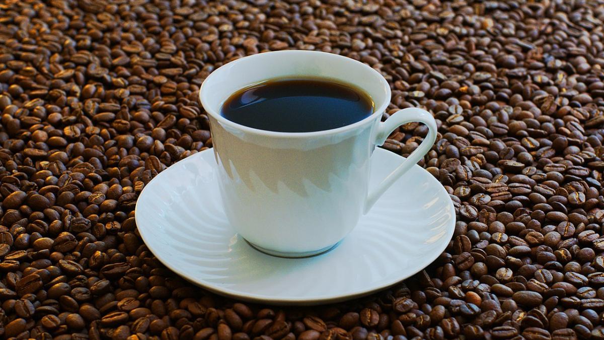 Чашка кофе в окружении кофейных зерен