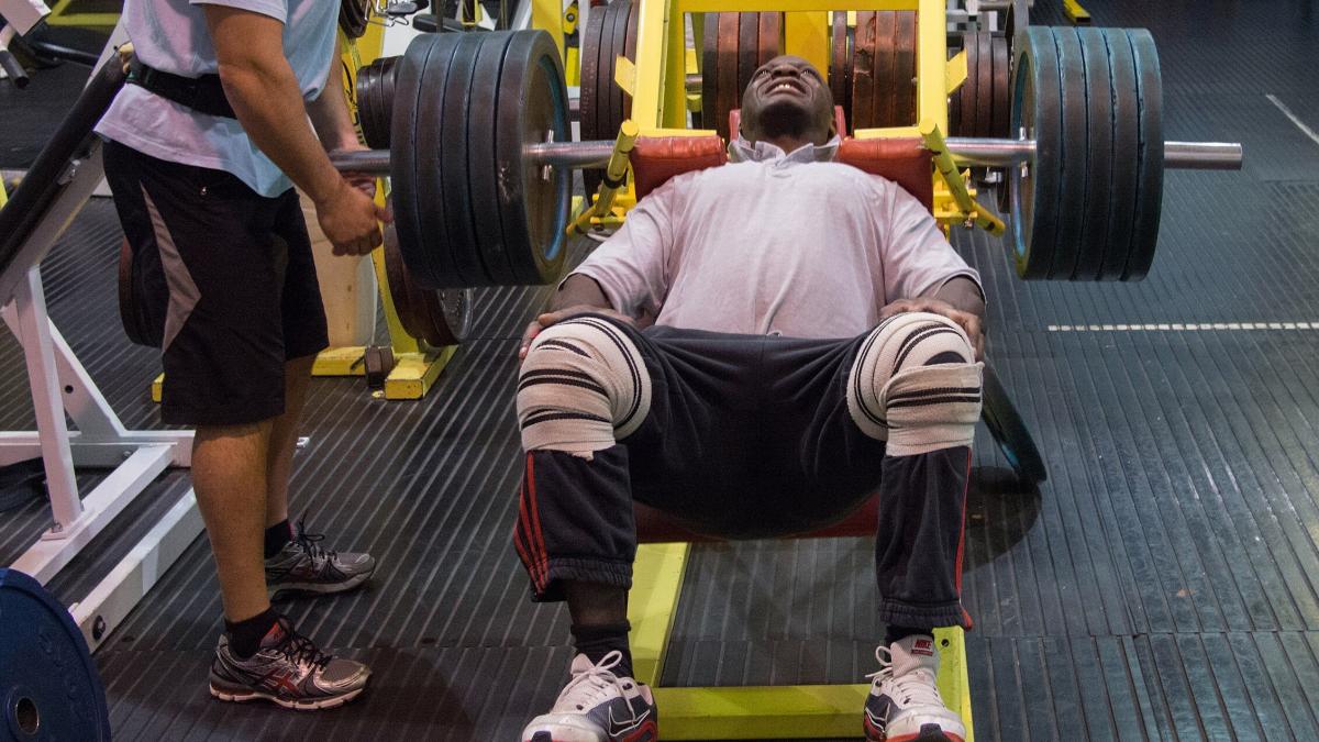 Выполнение упражнение на тренажере Hack Squat