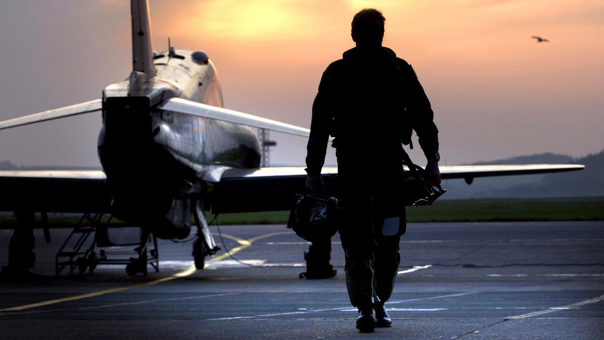 RAF Pilot Walking Away from Hawk Aircraft in Silhouette MOD 45154156 RAF Pilot Walking Away from Hawk Aircraft in Silhouette MOD 45154156