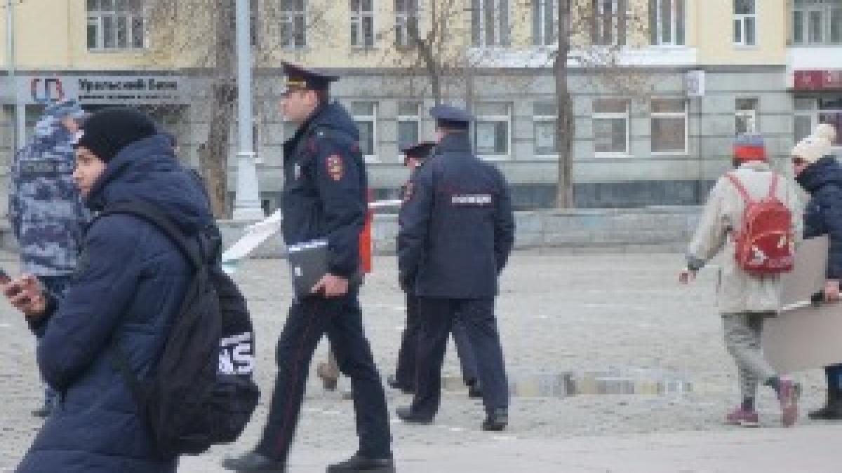Полицейский сопровождает задержанного 1 мая 2019 года в Екатеринбурге до автобуса