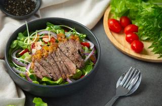 Слоёный салат с мясом и сыром собирают в кольцах диаметром около 10 см — повара