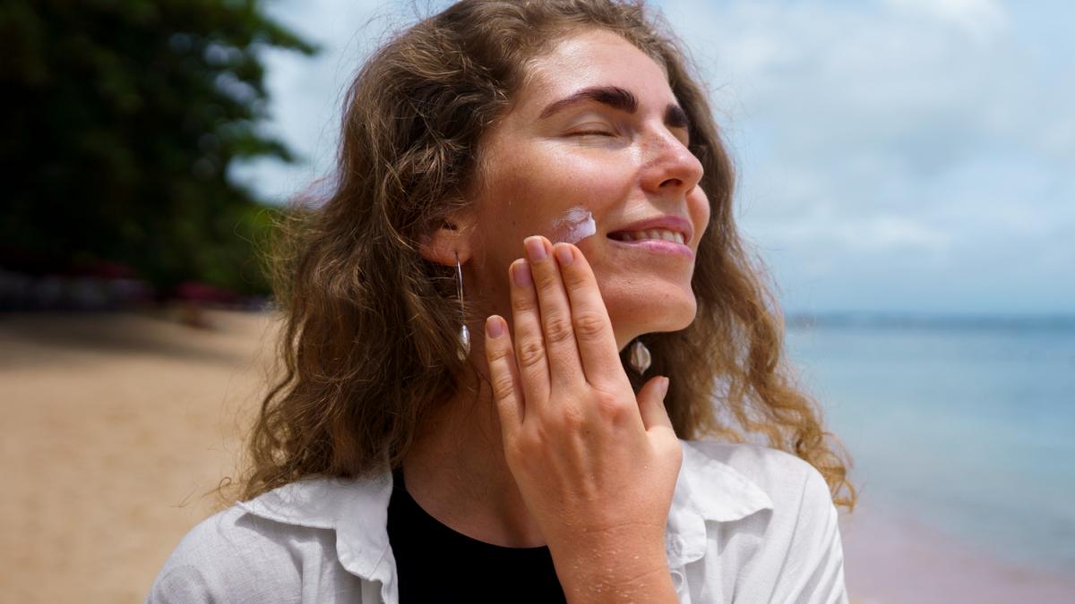 Девушка использует SPF-крем Девушка использует SPF-крем