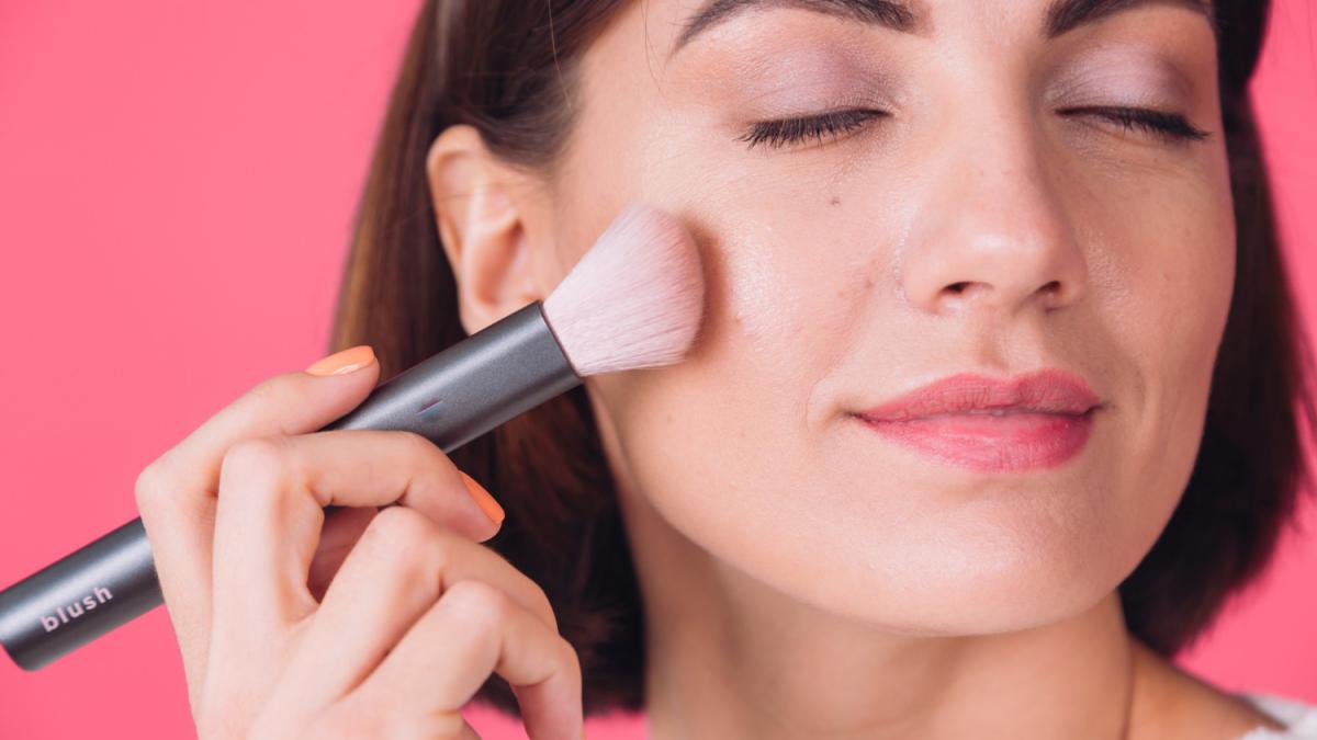 Девушка наносит румяна Девушка наносит румяна