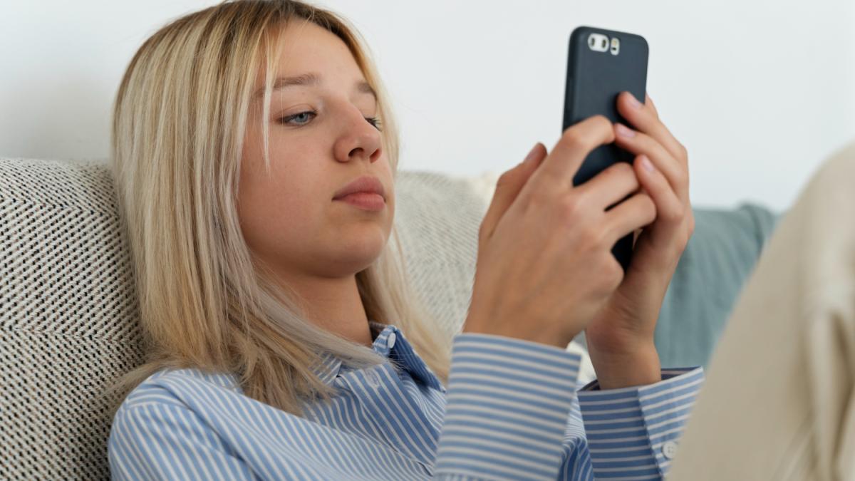 Девушка на диване со смартфоном