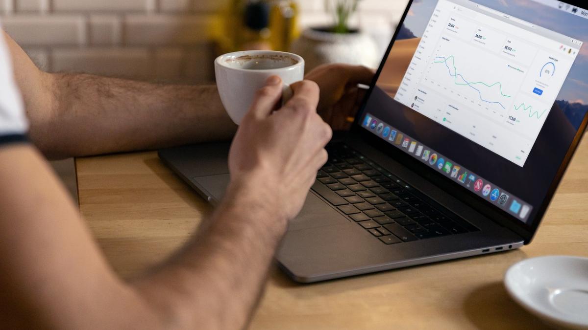 Фрилансер работает за ноутбуком, сидя в кафе