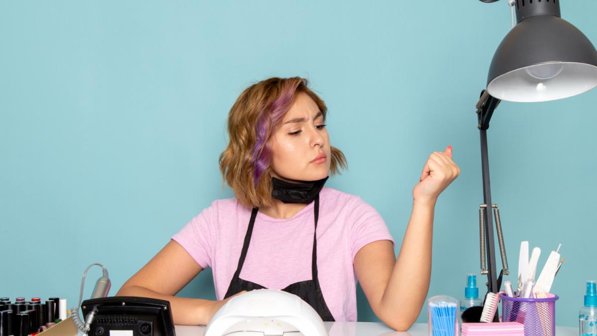 Мастер маникюра сидит за столом