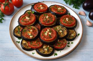 Запечённые кружочки баклажанов с помидорами получаются с золотистой корочкой — повар