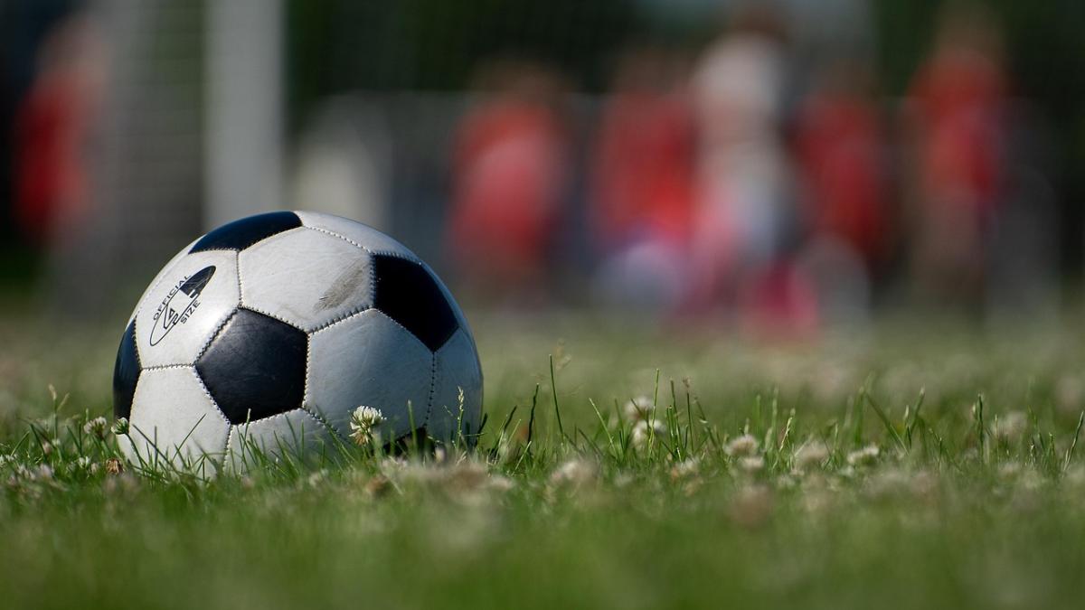 Футбольный мяч на зеленом поле, крупный план