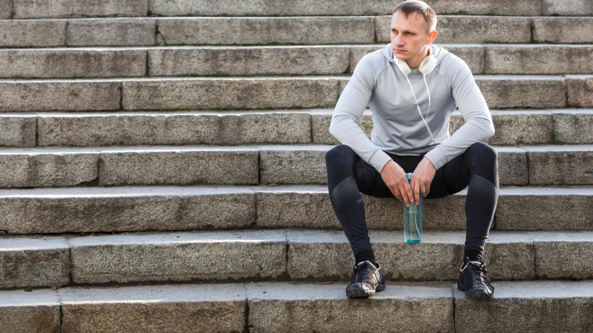 Спортсмен отдыхает на лестнице