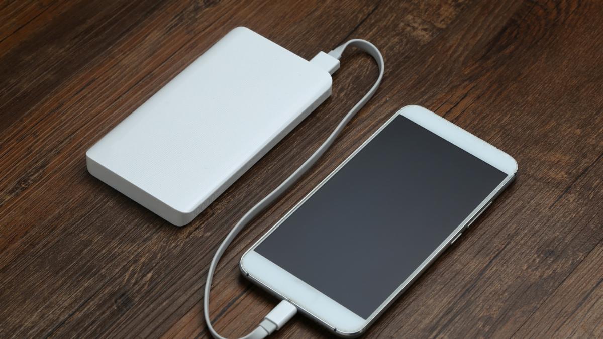 Powerbank и сотовый телефон на деревянном столе