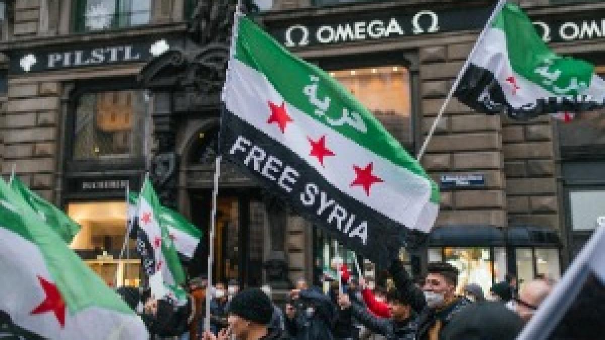 Protesters on the street holding Syrian flags with message "Free Syria" (51012078002)