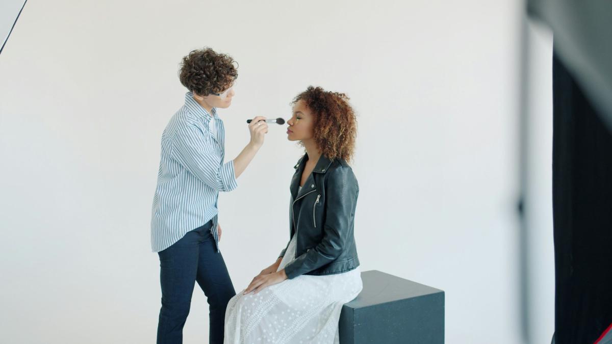 Кисть наносит румяна на щеку