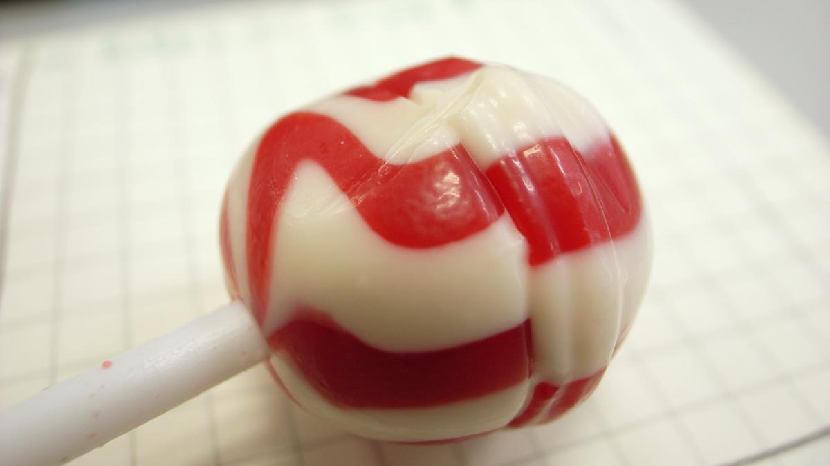 Red and white lollipop on checkered paper Red and white lollipop on checkered paper