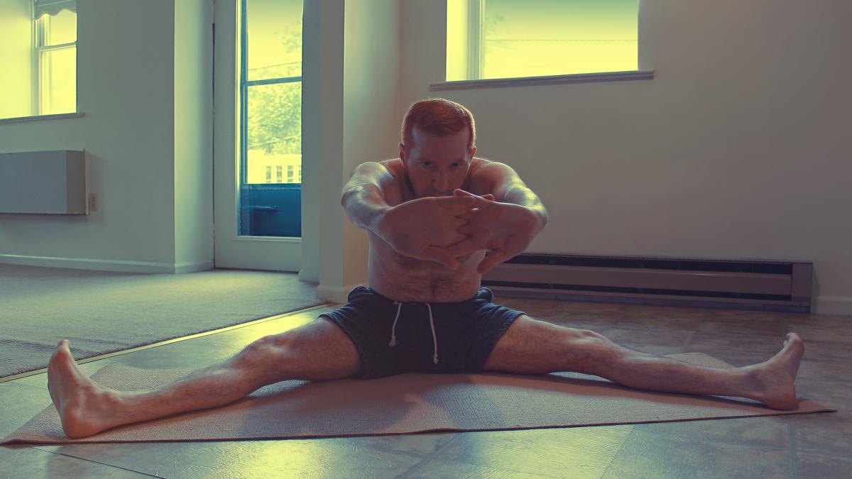 Мужчина делает растяжку мышц бедра